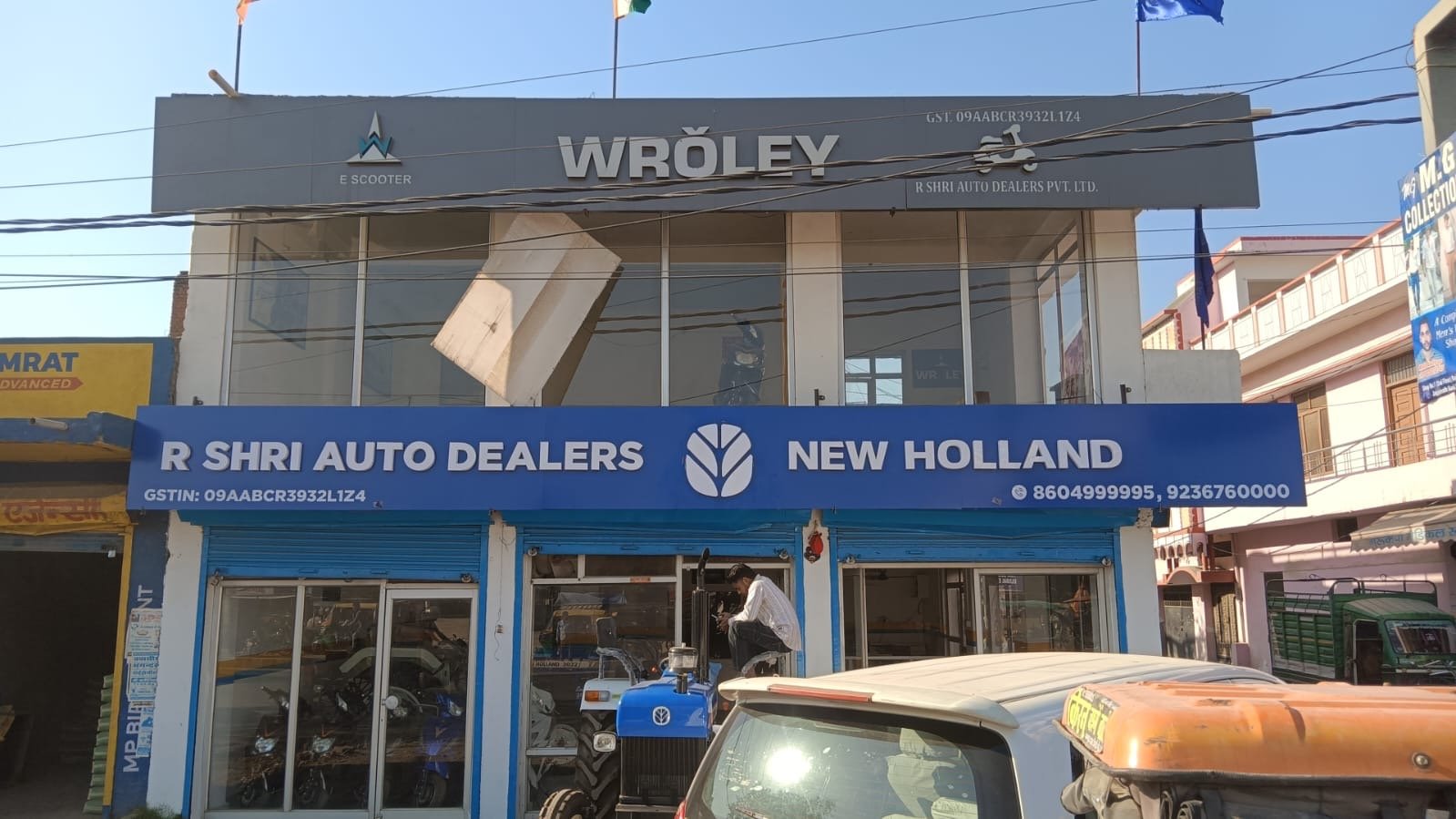 R Shri Auto Dealers New Holland showroom with branded ACP fascia and glow sign