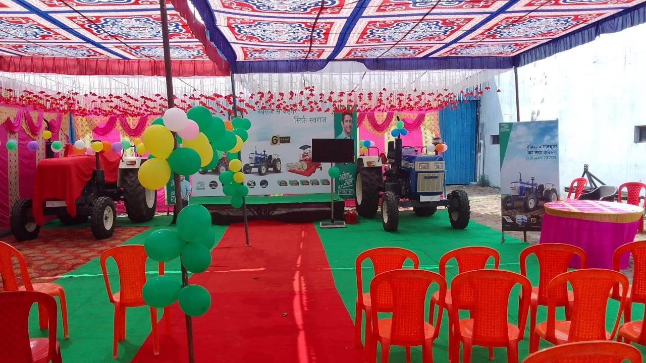 Swaraj customer meet under a decorated tent with tractors on display