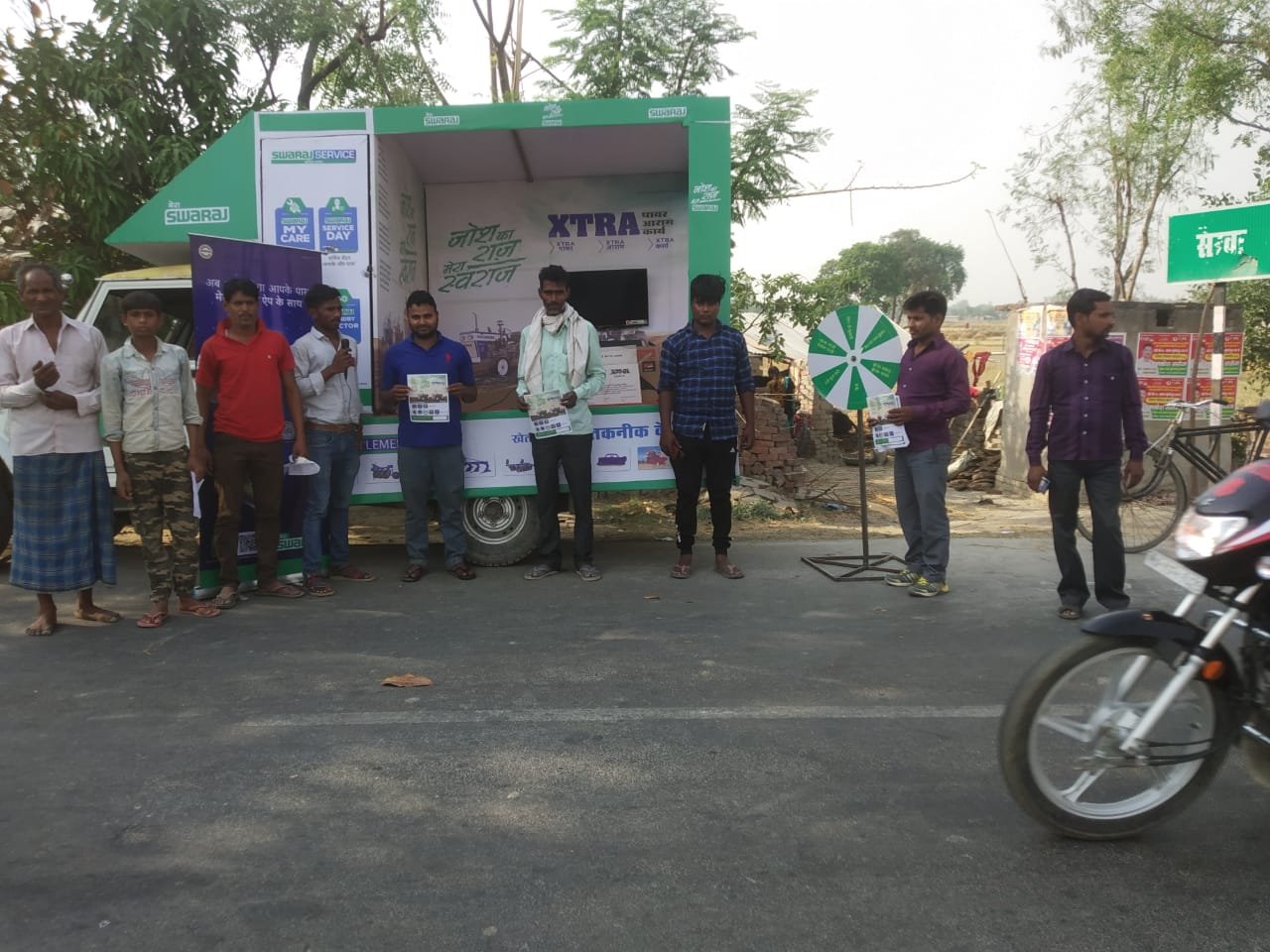 Swaraj XTRA branded van with the field team lined up beside it